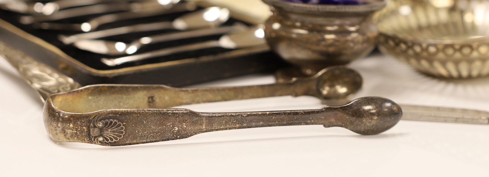 A pair of George V silver mounted candlesticks, weighted, 19.7cm, a silver vase, two pierced silver small dishes, a silver mounted penknife, George III silver spoon, a silver pepperette, pair of silver tongs, silver salt